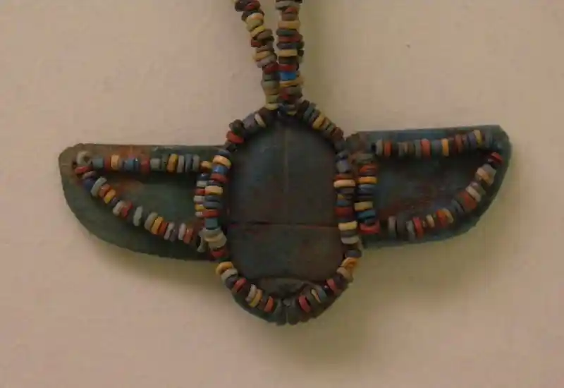 A colorful beads necklace with a winged disc pendant